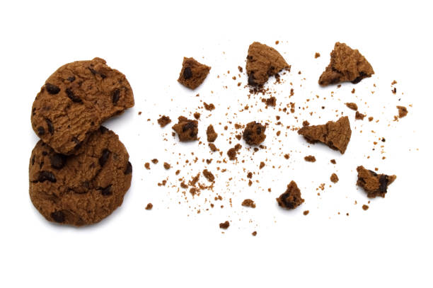 istock Chocolate chip cookies with some broken and crumbs isolated on white background. 1219845043
