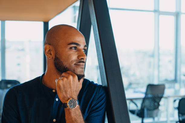 istock Handsome cheerful african american executive business man in office workspace. 1219847982