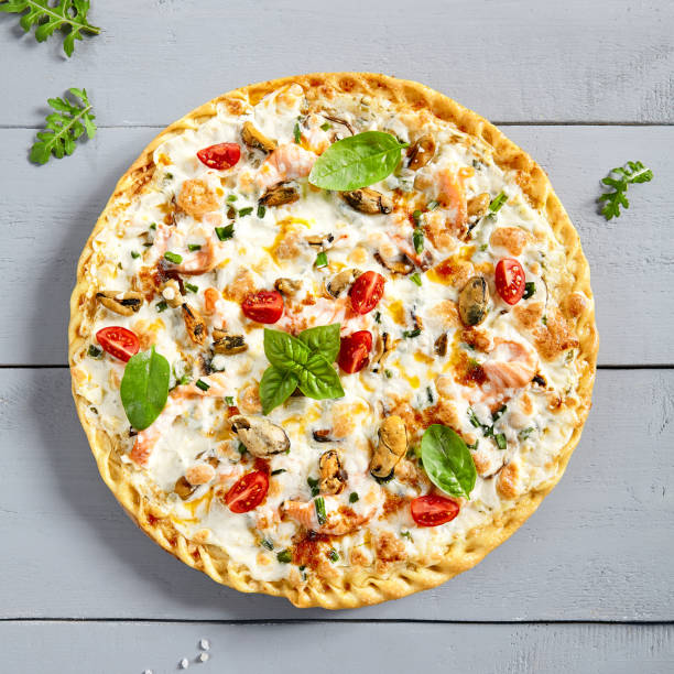 istock Seafood pizza on wooden board 1219848195