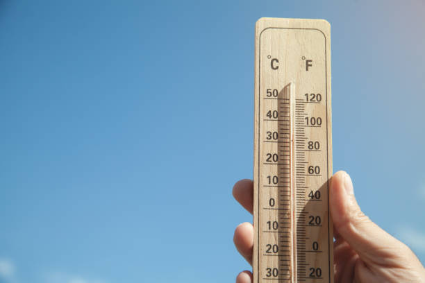 istock Hand holding thermometer on blue sky background. 1219848926