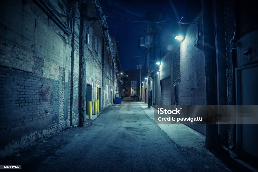 Dark and eerie urban city alley at night Alley Stock Photo