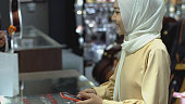 asiatische-muslimische-frau-mit-kontaktlosem-bezahlen.jpg?b=1&s=170x170&k=20&c=wNt1mryv9Dcq5AvE4CvkCbgLgRc-Tg7zWbSSY8J8YyY=