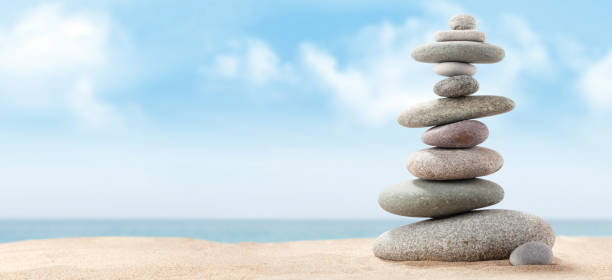 istock Pyramid of sea pebbles on a sunny sand beach 1219851826