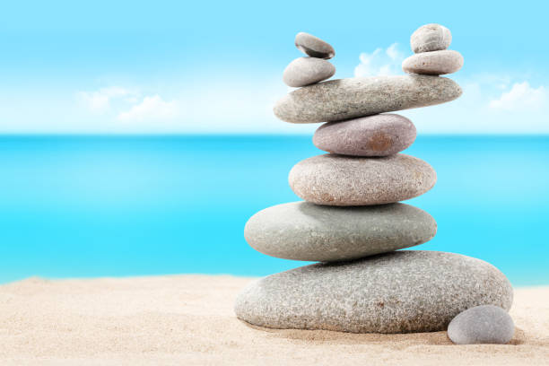 istock Pyramid of sea pebbles on a sunny sand beach 1219851838