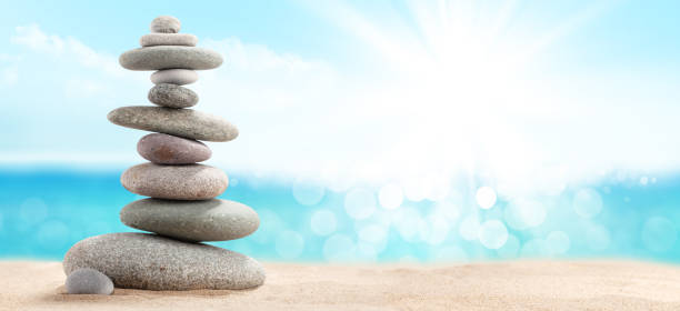 istock Pyramid of sea pebbles on a sunny sand beach 1219851852