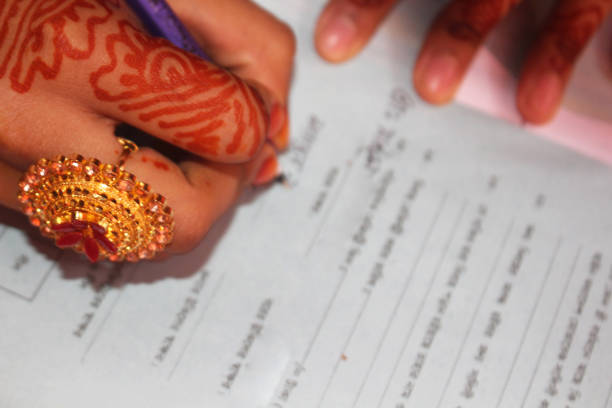 istock Beautiful bride signs the marriage registration documents. 1219854072