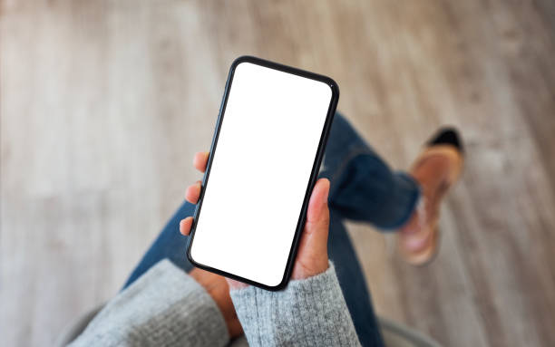 istock a woman holding mobile phone with blank white screen 1219855237