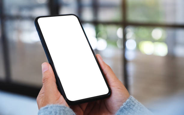 istock a woman holding mobile phone with blank white desktop screen 1219855245