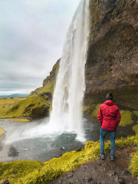 istock man under the waterfall in iceland 1219856556