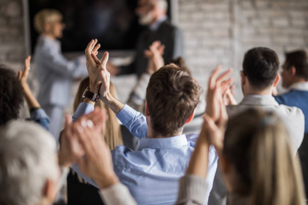 istock Back view of entrepreneurs applauding on a seminar in board room. 1219856924