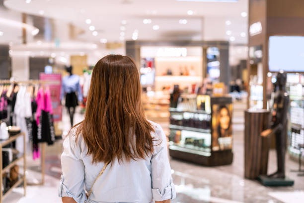 giovane donna asiatica che cammina nel negozio di abbigliamento al centro commerciale, concetto di stile di vita femminile - department store foto e immagini stock