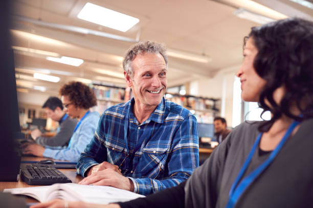 istock Group Of Mature Adult Students In Class Working At Computers In College Library 1219860711