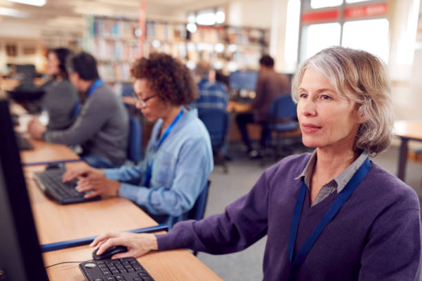 istock Group Of Mature Adult Students In Class Working At Computers In College Library 1219860805