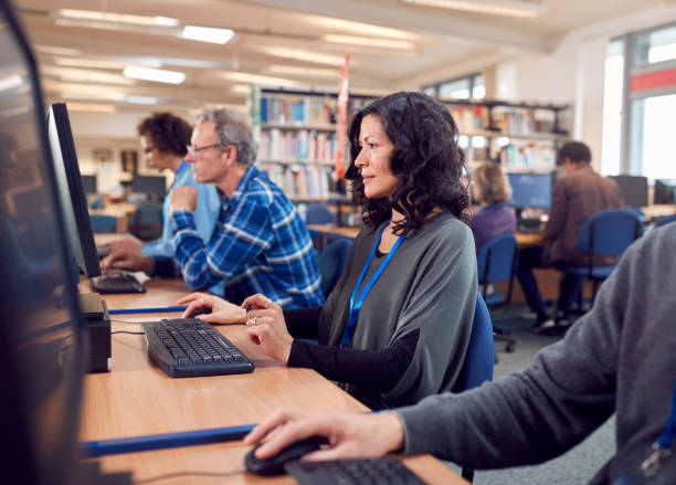 istock Group Of Mature Adult Students In Class Working At Computers In College Library 1219860869