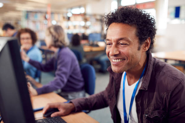 istock Group Of Mature Adult Students In Class Working At Computers In College Library 1219860939