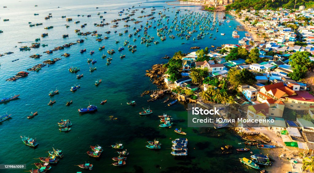 many multi-colored, beautiful ships in the sea. view from above many multi-colored, beautiful boats in the sea. there are many floating boats in turquoise water, panoramic shots from the air. Fishing Industry Stock Photo