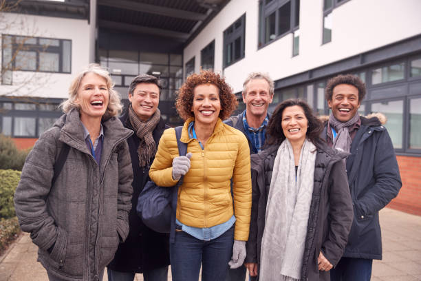 ritratto di gruppo di studenti maturi sorridenti in piedi fuori dall'edificio del college - night school foto e immagini stock