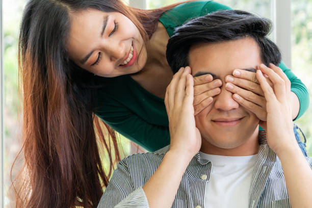 istock Young happy Asian couple having good time while stay at home 1219864218