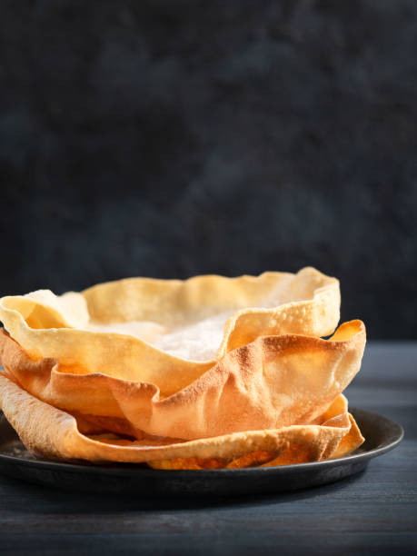 indyjskie przekąski. zbliżenie rustykalnego indyjskiego papadum ostre na ciemnym tle, kopiuj przestrzeń. selektywne skupienie. - chipping zdjęcia i obrazy z banku zdjęć