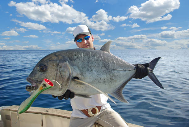Deep sea fishing. Trevally jack Catch of fish. Big game fishing, Happy  fisherman holding a big Trevally jack caranx stock pictures, royalty-free photos & images