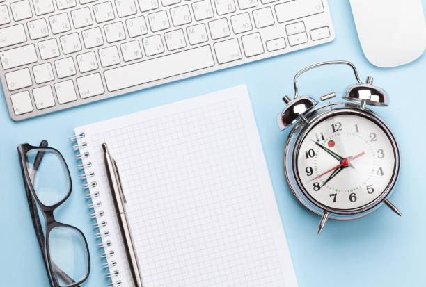 istock Blue workplace with computer, supplies and alarm 1219868294