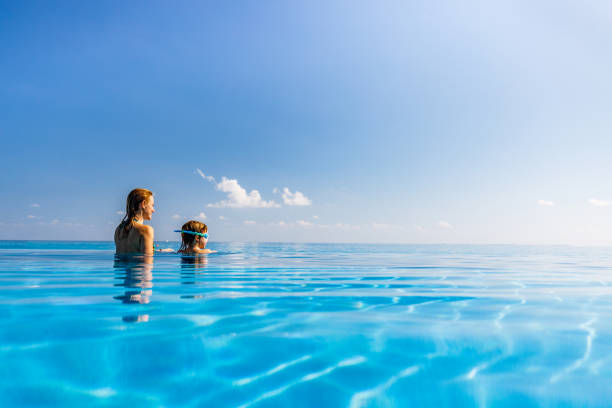 istock Single mother and her small son looking at view from an infinity pool. 1219869464