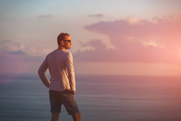 istock Man with nice tropical summertime sunset on the island above the ocean. 1219871216