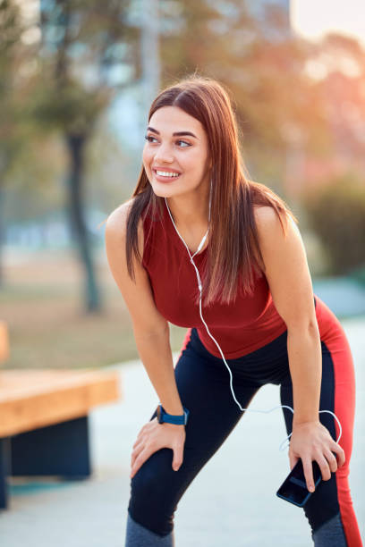 istock Modern young woman with cellphone making pause during jogging / exercise. 1219871429