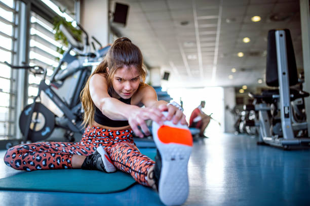 istock Smiling Young Woman Stretching on Mat at Gym 1219871504