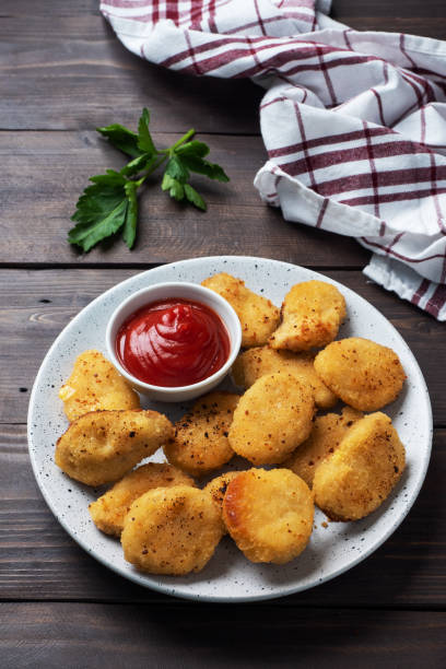 istock Fried chicken nuggets with tomato ketchup sauce. Wooden background. Copy space. 1219871528