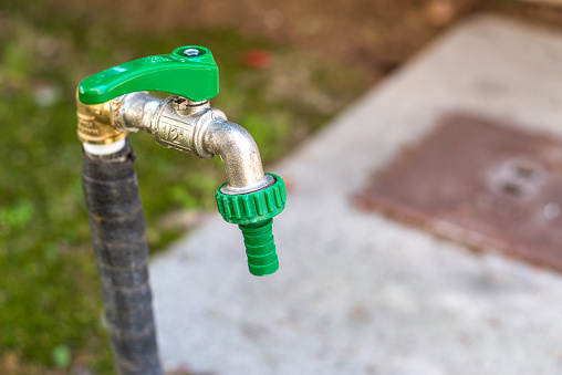 Close up of a water pipe in a domestic garden on a spring day. Selective focus