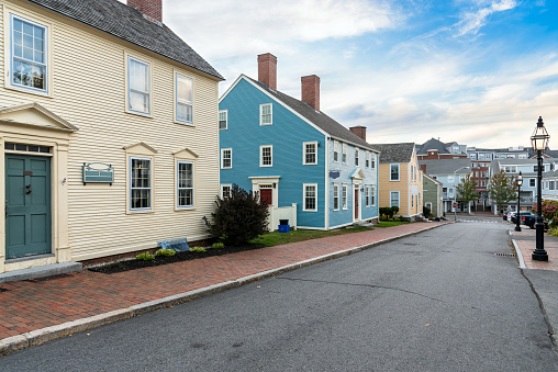 Street lined with traditional colourful New England detached houses in a residential district at sunset. Portsmouth, NH, USA