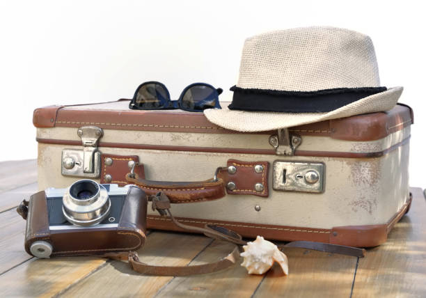 istock retro suitcase  and camera on punt on a wooden table with straw hat and glasses on white background 1219873628