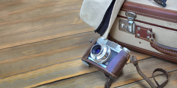 istock retro suitcase and camera on wooden background with straw hat 1219873836