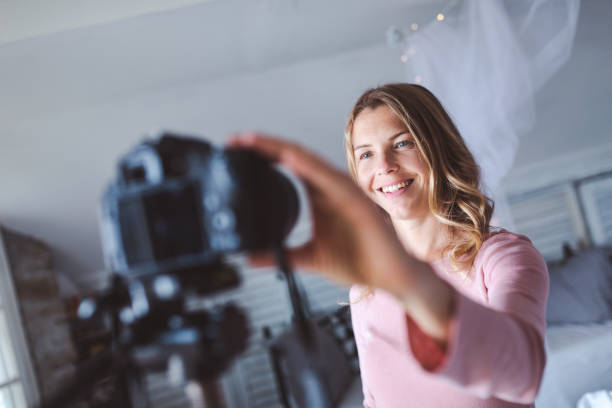 istock Happy female vlogger live streaming from living room 1219874078