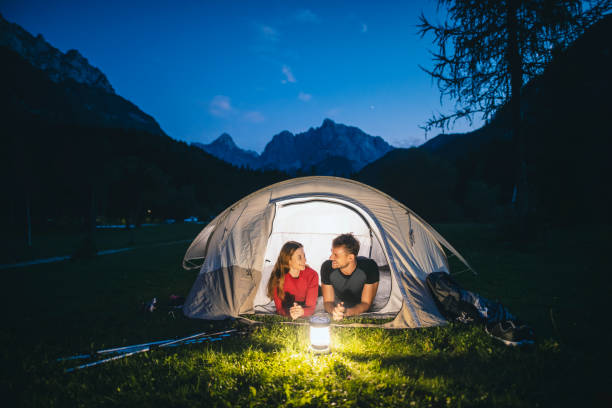 coppia di campeggi sdraiata sul portico della tenda e vista ammirata - european alps women summer outdoor pursuit foto e immagini stock