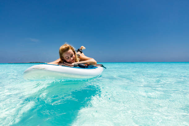 istock Happy woman enjoying while sunbathing on paddleboard at sea. 1219875159