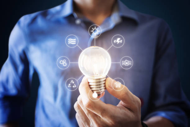 istock Businessman holding bright light bulb with energy resources icons on hand 1219877130
