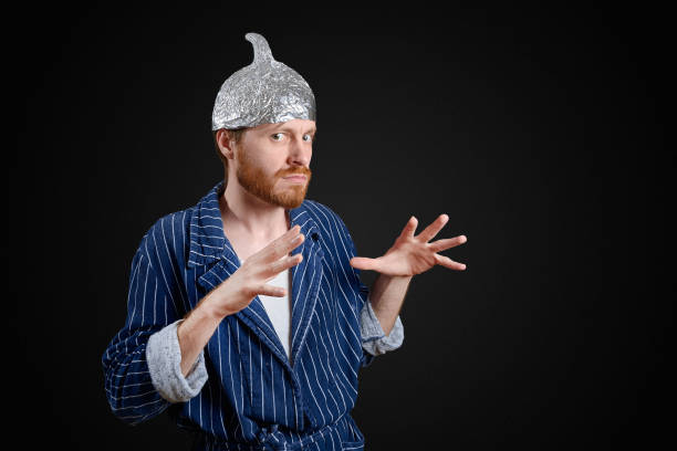 scared man in foil cap and old holey bathrobe scared man in foil cap and old holey bathrobe tin foil hat stock pictures, royalty-free photos & images