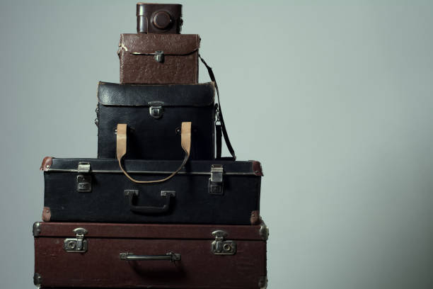 istock Background stack of old shabby suitcases and camera 1219879786
