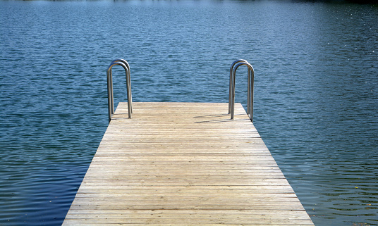 Wooden pier on blue water lake.