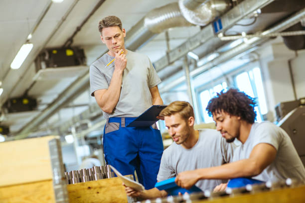 istock Senior male inspector doing quality control with manual worker looking at document 1219886030