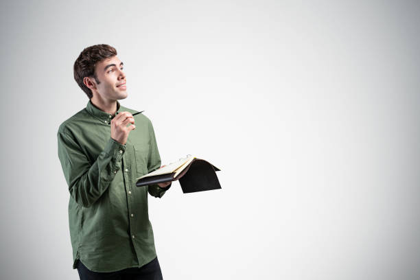 istock Smiling casual man with notebook, mock up 1219886444