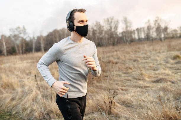 istock Guy in a medical mask is jogging 1219887892