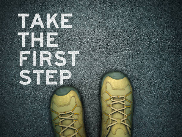 feet on asphalt road with take the first step phrase - 3d rendering - foco em primeiro plano imagens e fotografias de stock