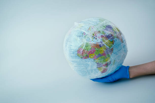 istock doctor with a world globe wrapped in plastic 1219889870