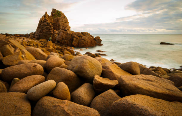 istock Slow moving waves crashing on a beach with mysterious rock formations 1219890368