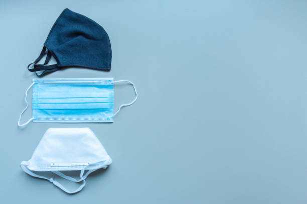 istock Different face masks and respirator on blue background. Protection against virus 1219891506