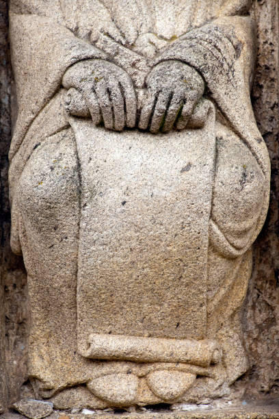Stone hands holding a scroll , detail of a starue in one of the facades of the Santiago de Compostela Cathedral, by the Holy Door, XVI century. Galicia, Spain.