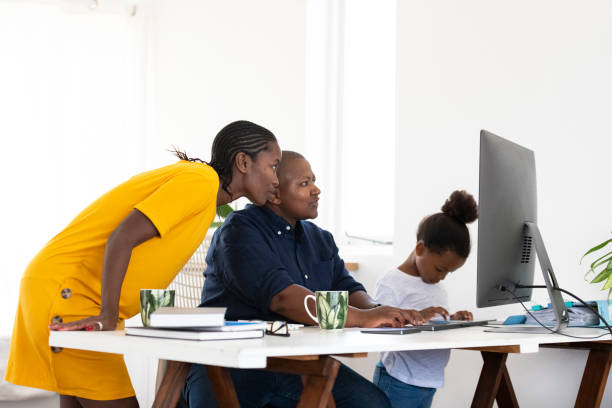istock Lesbian couple using desktop while daughter uses digital tablet in home office 1219893336